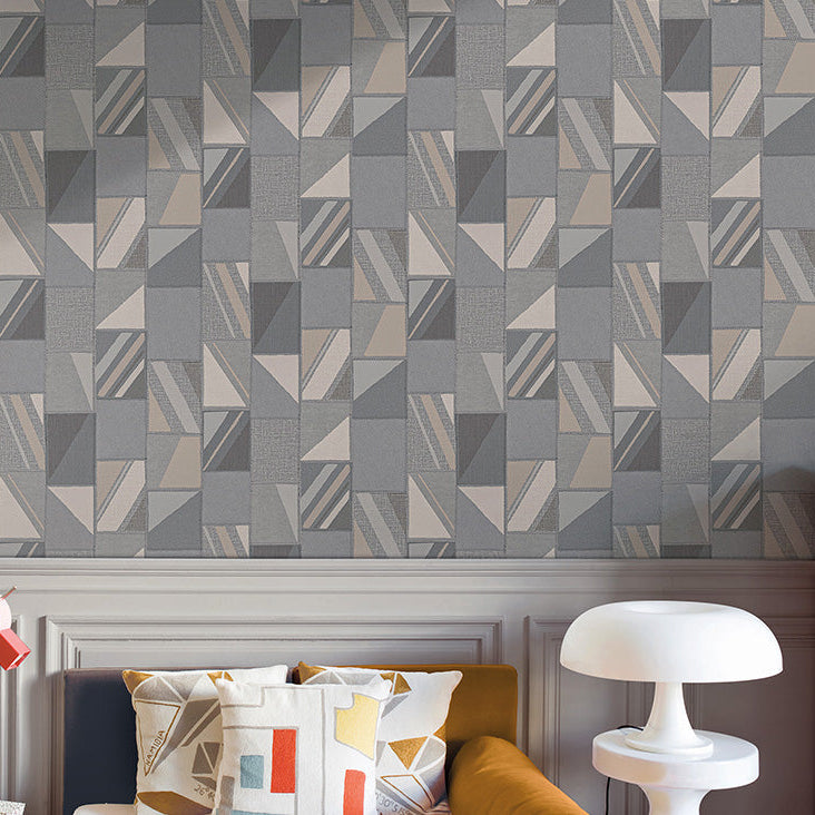 Geometric patterned wallpaper in a room with a sofa and decorative items.